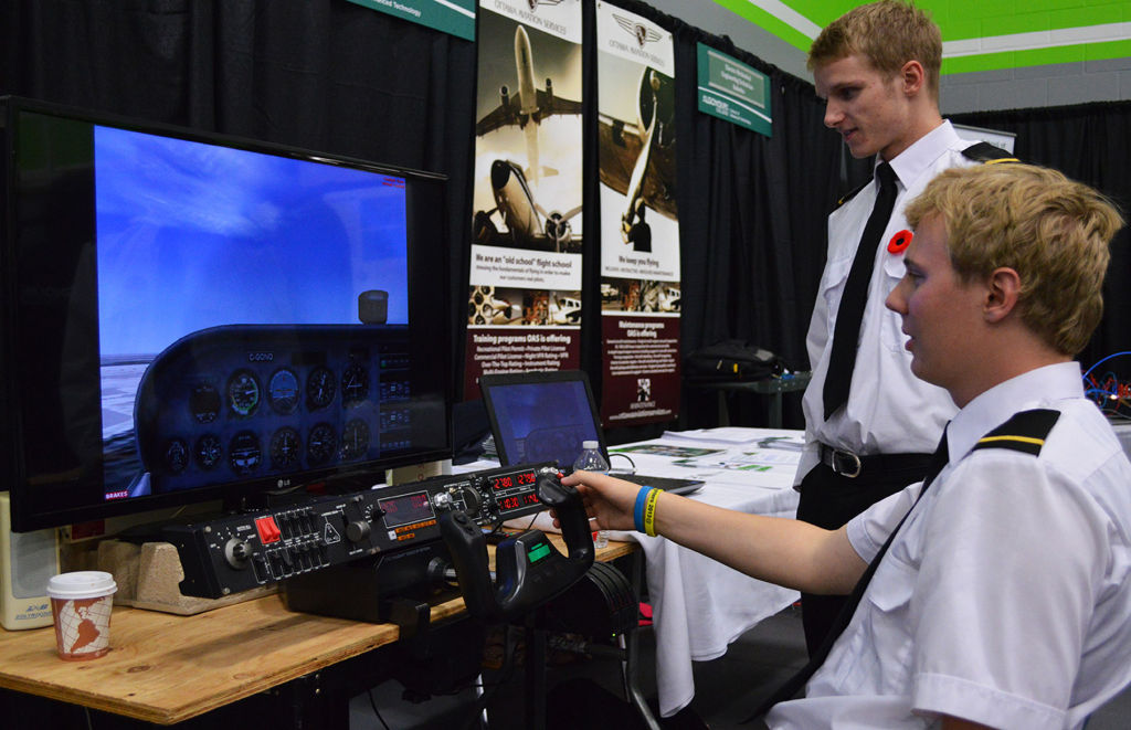 Isaac Sleingley and Logan Goulette showcase the flight simulator at the aviation booth during Algonquin's open house for future students.