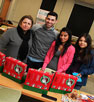 Maria Silvasi, Josh Hayes, Amanda Karam and Cecilia Garcia display shoeboxes filled with school supplies. About 30 boxes were donated by students.